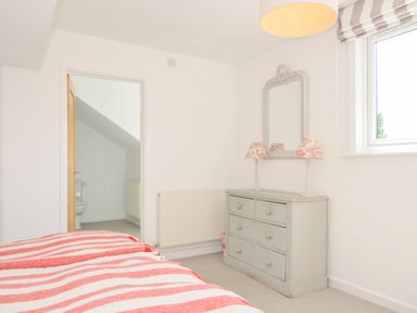 A bedroom with a bed and dresser at Porthilly Brook in Rock