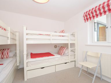 A bedroom with bunk beds and a chair at Porthilly Brook in Rock