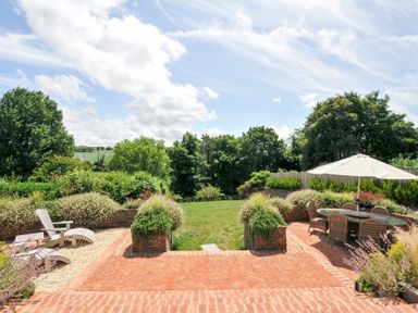 A garden with a patio and seating area at Porthilly Brook in Rock