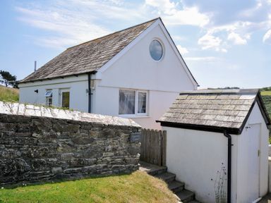 A house with a shed and stone wall at Cartway Cabin Port Isaac