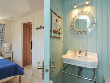 A bathroom with a sink and mirror at Cartway Cabin, Port Isaac
