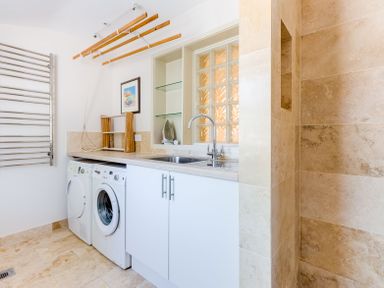 A laundry room with a washing machine dryer sink and drying racks at Lowenna Manor 10 in Rock