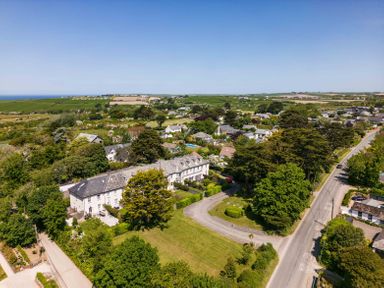 A residential area with houses trees and roads surrounded by fields at Lowenna Manor 10 in Rock