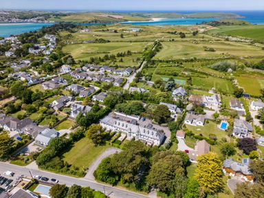 A coastal village with houses gardens a golf course and the sea in the background at Lowenna Manor 10 in Rock