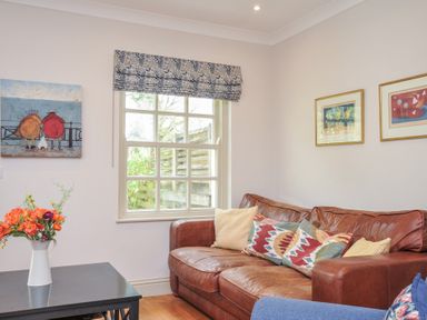 A living room with a sofa and a table with flowers at Lowenna Manor 10 Rock