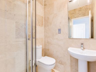A bathroom with a toilet shower enclosure sink and mirror at Rock Lobster in Port Isaac