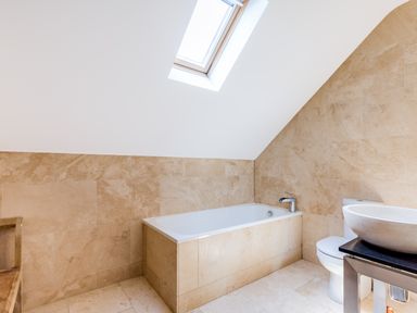 A bathroom with a bathtub toilet sink and skylight window at Rock Lobster in Port Isaac
