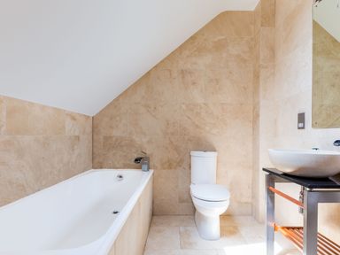 A bathroom with a bathtub toilet and a sink with a mirror at Rock Lobster in Port Isaac