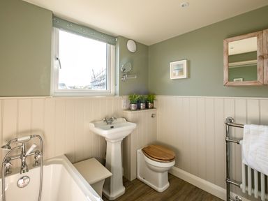 A bathroom with a bathtub sink toilet and mirror at Atlantis Polzeath