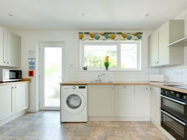 A kitchen with washing machine microwave oven toaster and sink at Tremay in Rock