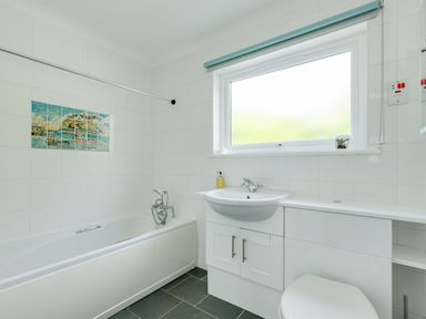 A bathroom with a bathtub sink toilet and a window at Tremay in Rock