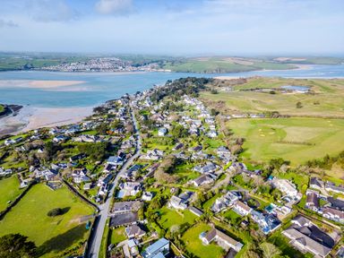 An aerial view of a coastal village with houses roads green fields and water at Rock Hill in Rock