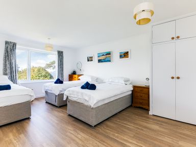 A bedroom with three beds a window wooden drawers and built in wardrobes at Rock Hill in Rock