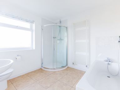 A bathroom with a shower enclosure bathtub sink towel radiator and window at Rock Hill in Rock