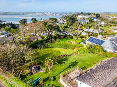A garden with trees and bushes overlooking a coastal town with water in the distance at Rock Hill in Rock