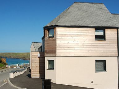 A street view of a modern house near the coast with a road leading to the beach at The Beach Hut in Polzeath