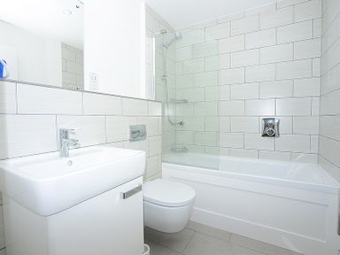 A bathroom with a sink, toilet, and bathtub with shower at The Beach Hut in Polzeath