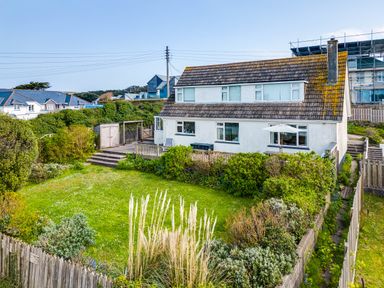 A house with a fenced garden and shrubs at Bella Vista in Polzeath