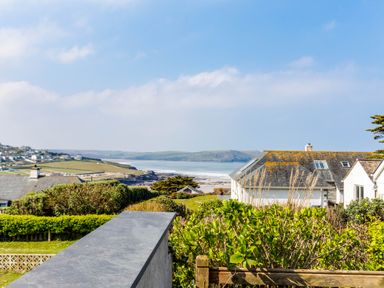 A coastal view with houses greenery and the sea in the background at Bella Vista in Polzeath