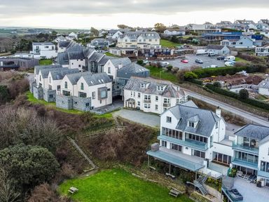 A residential area with houses and parking spaces surrounded by greenery at Pinewood Flat 5 in Polzeath