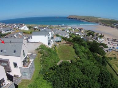 A coastal village with houses near a beach and a headland with the sea in the background at Kellan in Polzeath