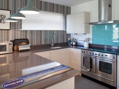A kitchen with a stove microwave toaster kettle and kitchen sink at Kellan in Polzeath
