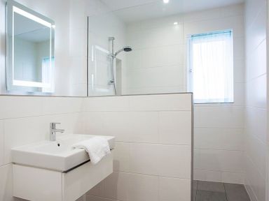 A bathroom with a sink and towel a walk in shower and a window at Kellan in Polzeath