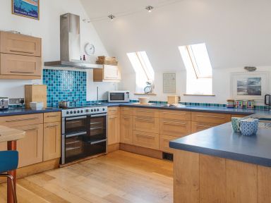 A kitchen with wooden cabinets a stove and blue tiled backsplash at Sandy Hills 8 in Rock