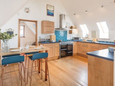 A kitchen with wooden cabinets blue countertops and stools at Sandy Hills 8 in Rock