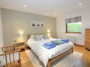 A bedroom with a double bed and bedside tables with lamps at Sandy Hills 8 in Rock