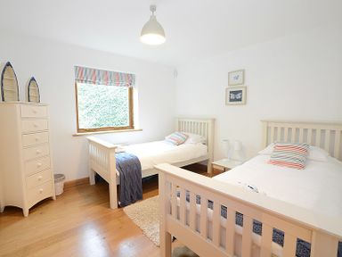A bedroom with two single beds a chest of drawers and a window at Sandy Hills 8 in Rock