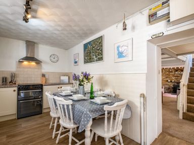 A kitchen with a dining table set for six and a stove with an extractor hood at St Michaels in Rock