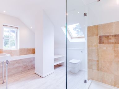 A bathroom with a bathtub a toilet a sink and a glass shower at Greystones in Daymer Bay