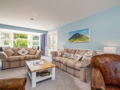 A living room with striped sofas a wooden coffee table and leather armchair at Cherrytrees in Rock