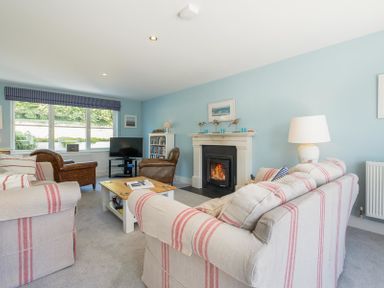 A living room with sofas a fireplace a television and a coffee table at Cherrytrees in Rock