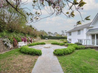 A garden with flowers, a bench, and a pathway at Cherrytrees in Rock