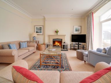 A living room with sofas a fireplace a television and a coffee table at The Haven in Daymer Bay