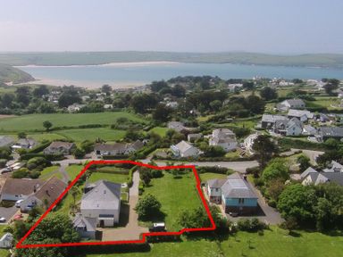 A residential area with houses and green lawns near a beach at The Haven in Daymer Bay