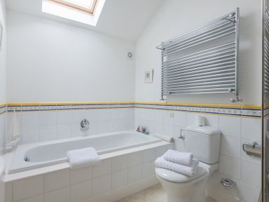 A bathroom with a bathtub a toilet a towel rack and towels at Penny Liggan in Rock