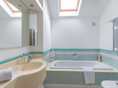 A bathroom with a bathtub and a sink under skylights at Penny Liggan in Rock