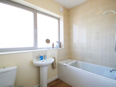 A bathroom with a toilet sink and bathtub with shower at The Holiday House 2 Atlantic Mews in Polzeath