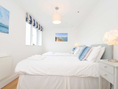 A bedroom with two beds and wall art at Stepper Point in Polzeath