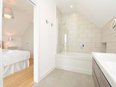 A bathroom with a shower and bathtub at Stepper Point in Polzeath