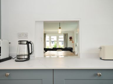 A kitchen with an opening to a living room at Corriana in Rock