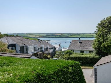 Houses with sloped roofs near a body of water with boats and green fields in the background at Drifters in Rock