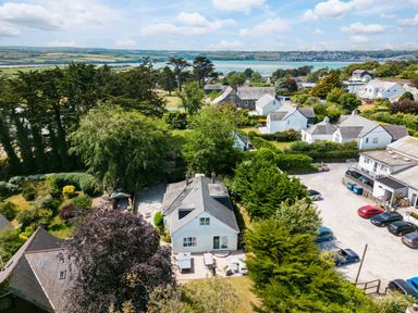 A residential area with houses gardens trees and a view of water at Sandy Lodge Rock in Rock