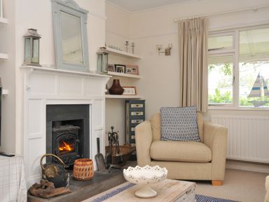 A living room with a fireplace and armchair at Sandy Lodge Rock