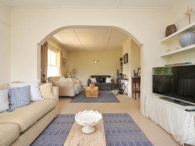 A living room with a sofa and a television at Sandy Lodge Rock