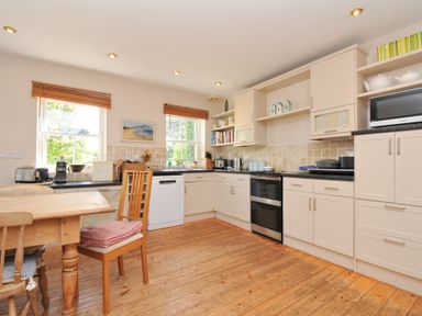 A kitchen with wooden floor and appliances at Sandy Lodge Rock