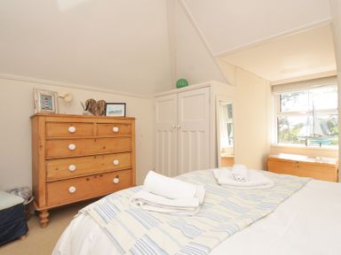 A bedroom with a bed and chest of drawers at Sandy Lodge Rock